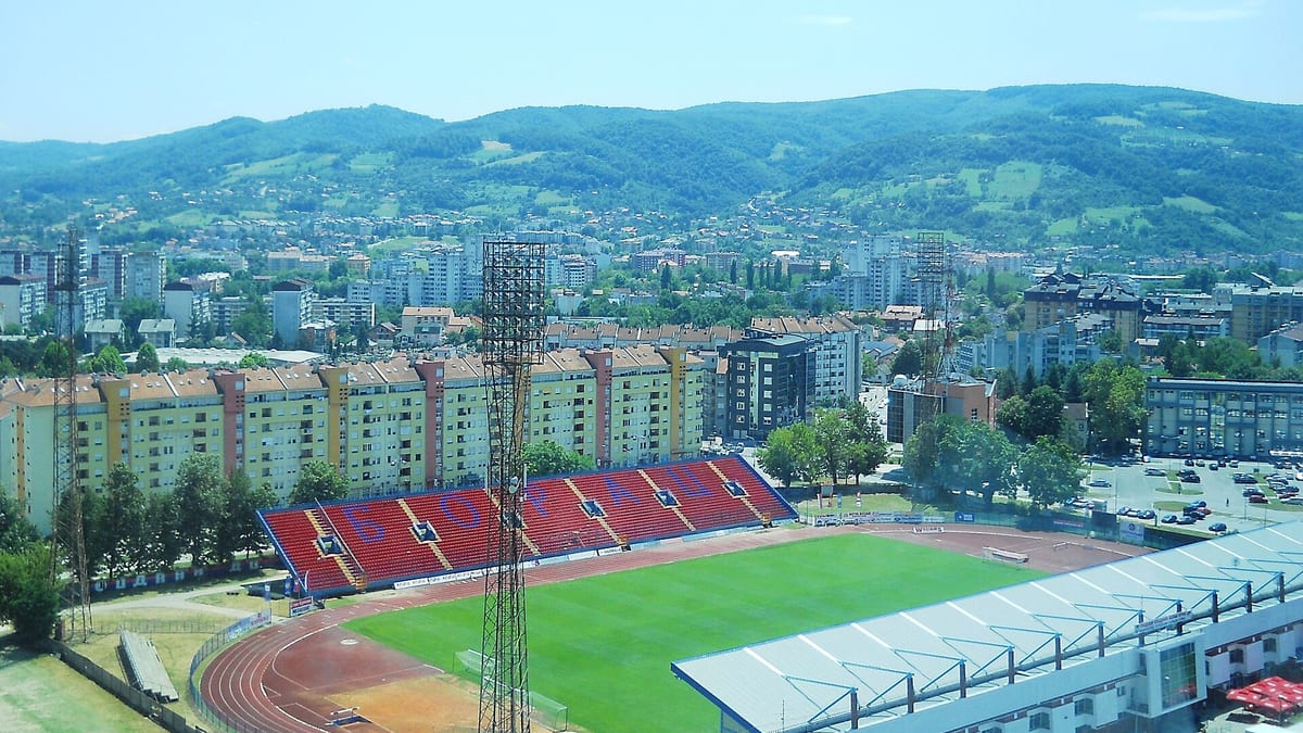 Gradski stadion u Banjoj Luci odozgo, crveno-plava tribina s ćiriličnim natpisom Borac, iza nje zgrade i brda