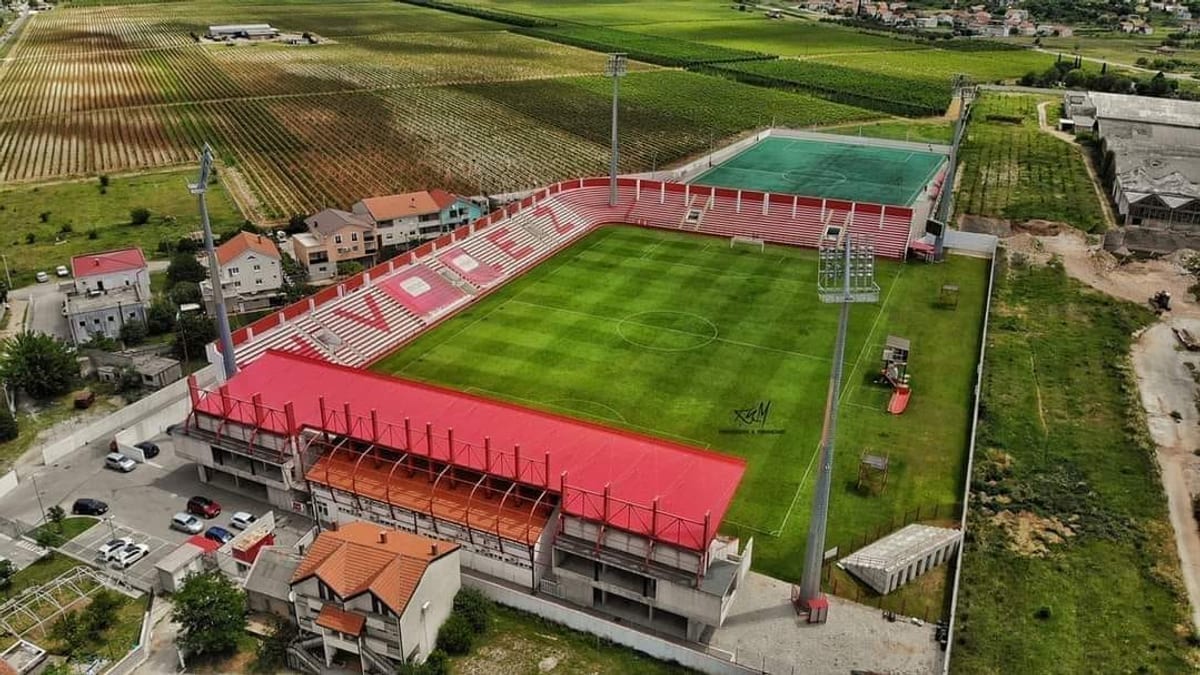 Stadion Rođeni u Vrapčićima iz zraka, s crvenim tribinama i natpisom Velež na sjedalima