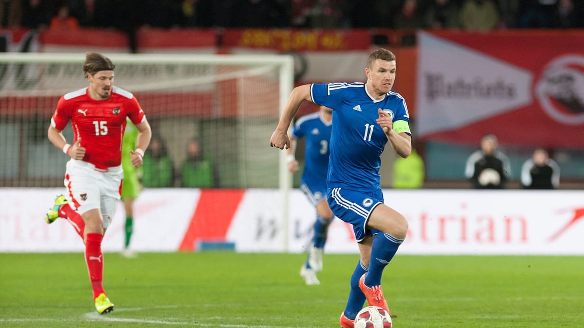 Edin Džeko s kapitenskom trakom i brojem 11 u plavom dresu reprezentacije BiH vodi loptu na utakmici protiv Austrije u Beču 2015.
